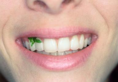 Woman with lettuce in teeth, close up